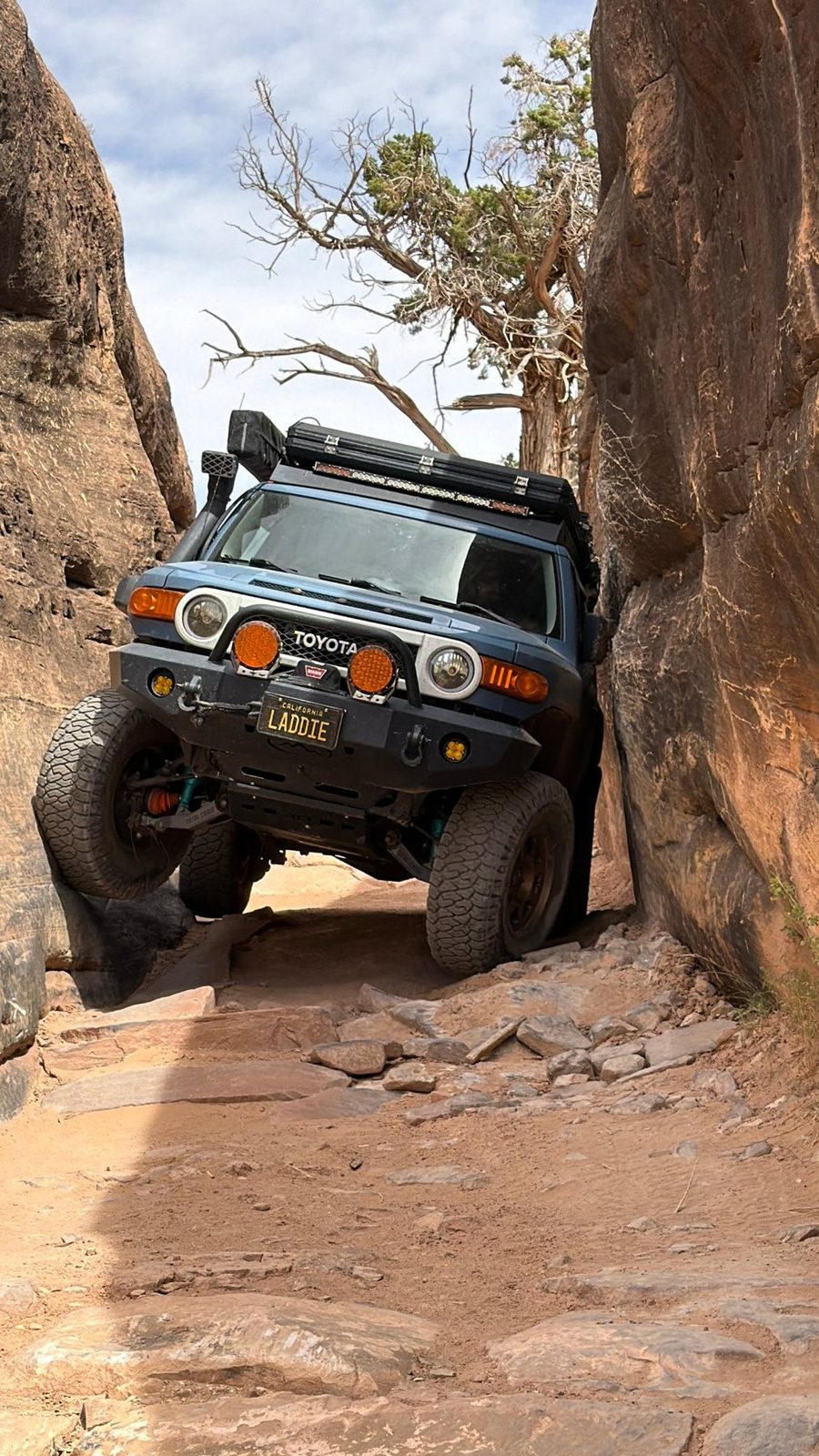 Erik's blue FJ Cruiser flexed through a sandstone slot