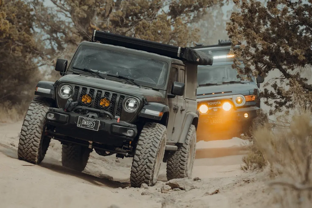 Jeep Gladiator Rubicon climbing a sandy trail, FJ Cruiser behind it