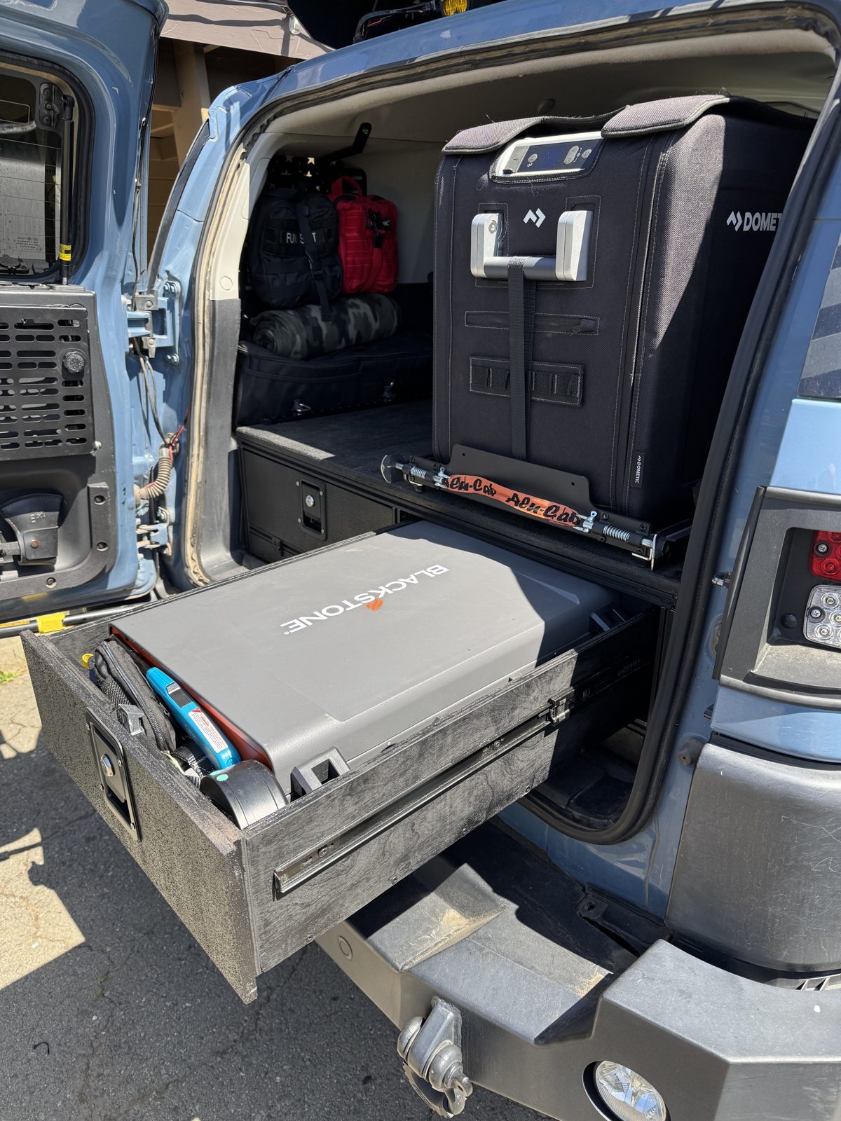 Slide extended and tilted at the tailgate, griddle drawer open below