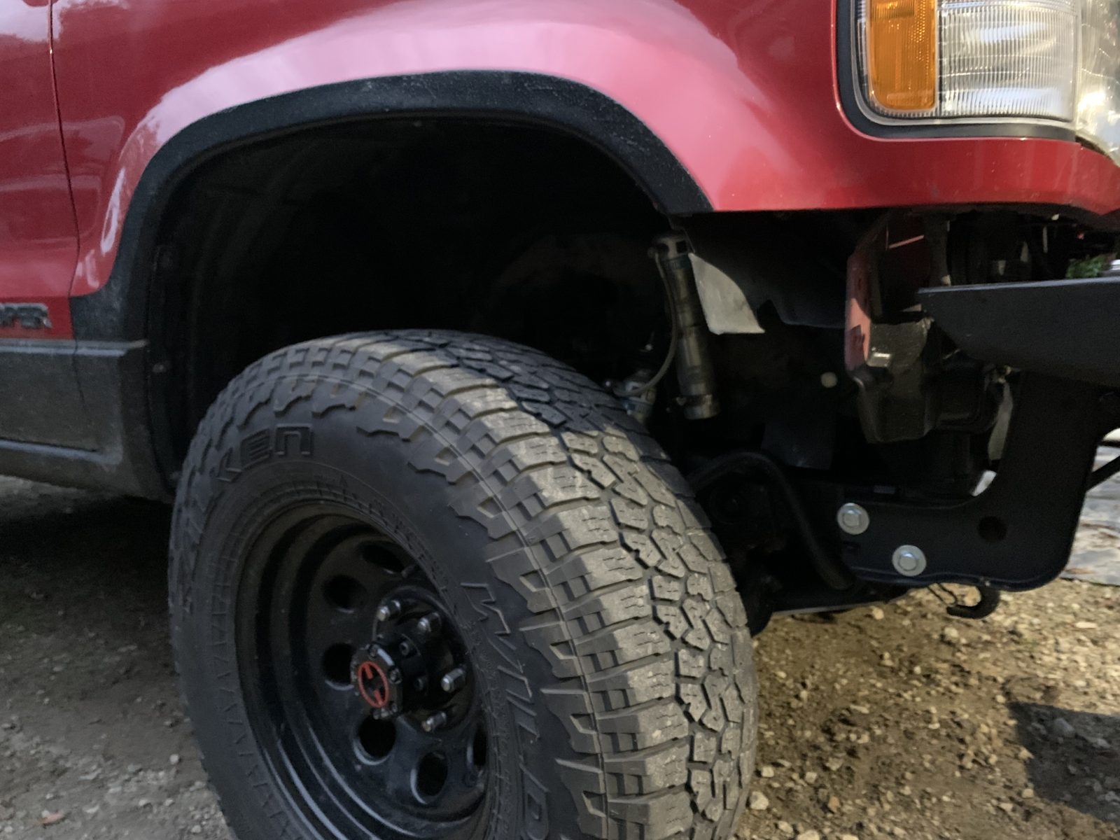 Close view under the Trooper's front corner: the added support bracket bolted below the bumper, toward the frame